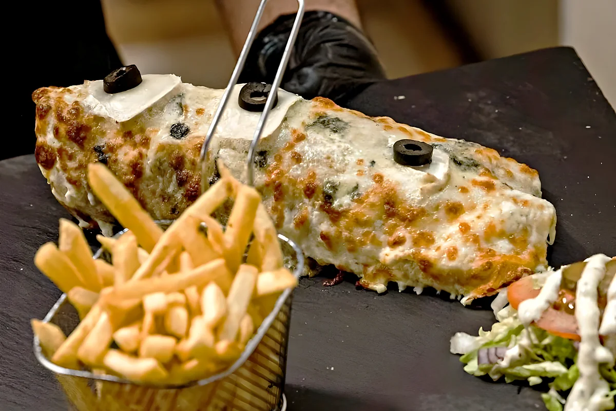 Tacos Signature gratiné servi sur ardoise, avec son panier de frites maison et sa salade